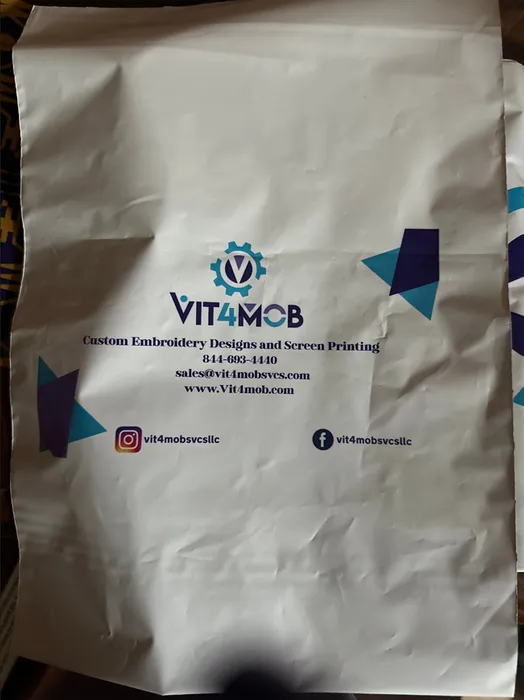 This image shows a white poly mailer with custom branding, including a logo, contact information, and social media icons for 'VIT4MCB Custom Embroidery Designs and Screen Printing.'